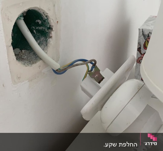 חוטי חשמל יוצאים מקיר עם תקע חשמלי
